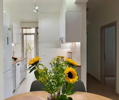 a kitchen with a table with a vase of sunflowers at Kalliso City Apartment near the beach in Chania Town