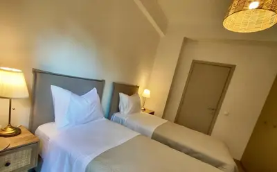 two beds in a hotel room with white sheets at Kalliso City Apartment near the beach in Chania Town