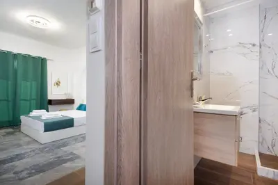 a bathroom with a shower and a sink and a bed at Anastasia Veridian Living in Kalathas