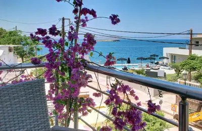 a view of the ocean from a balcony with purple flowers at Elpida's Gοds in Chania Town