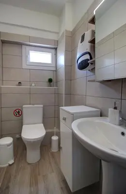 a bathroom with a white toilet and a sink at Elpida's Gοds in Chania Town