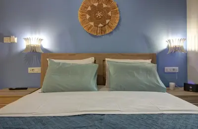 a bedroom with a large bed with blue walls at Elpida's Gοds in Chania Town
