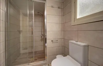a bathroom with a toilet and a glass shower at Elpida's Gοds in Chania Town