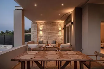 a living room with a wooden table and chairs at Kymélia Luxury Residences With Sea View in Galatás