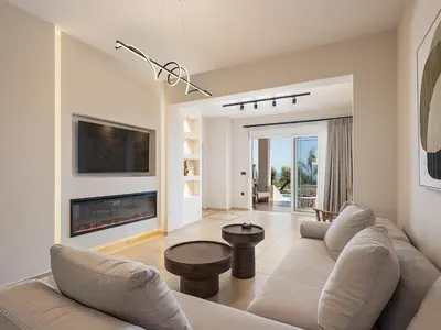 a living room with a couch and a fireplace at Kymélia Luxury Residences With Sea View in Galatás