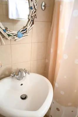 a bathroom with a sink and a shower curtain at Mera Beachfront House - Falasarna in Falasarna