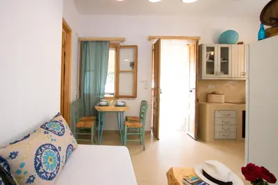 a room with a bed and a kitchen with a table at Mera Beachfront House - Falasarna in Falasarna