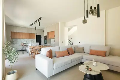 a living room with a white couch and a kitchen at Madre Tierra Boutique Villas 1 & 2 in Liyidhés