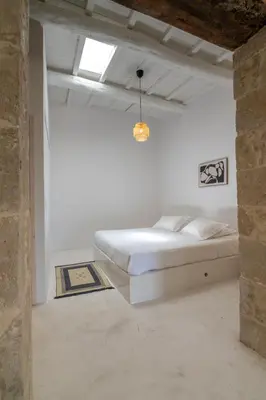 a bedroom with a bed in a white room at The Mulberry Stonehouse Mountain - Sea View in Kalleryianá