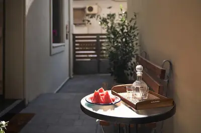 a table with a plate of watermelon and a bottle on it at Spiti an urban heaven in Chania Town