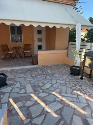 a patio with a white canopy and a table and chairs at Two little olives Studio apartment in Kissamos