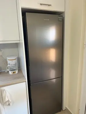 a stainless steel refrigerator in a kitchen next to a counter at Two little olives Studio apartment in Kissamos