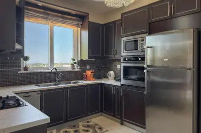 a kitchen with black cabinets and a stainless steel refrigerator at Kyparisses Villa with Private Pool in Chania Town