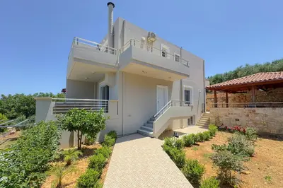 a white house with a balcony and stairs on it at Kyparisses Villa with Private Pool in Chania Town