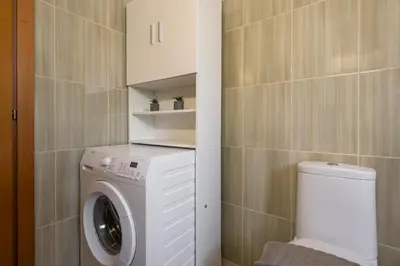 a bathroom with a washing machine and a toilet at Kyparisses Villa with Private Pool in Chania Town