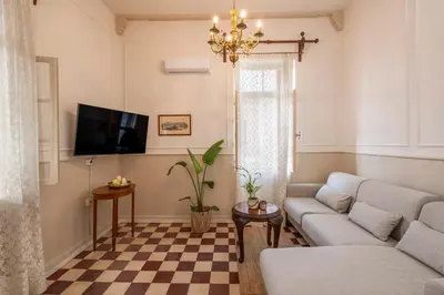 a living room with a couch and a checkered floor at Le Nid The Nest of Beauty in Chania Town