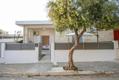 a white house with a tree in front of it at Dida stone home in Chania Town