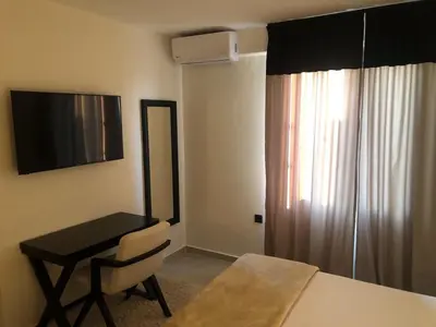 a room with a bed and a desk and a window at Casa del Sol - Kalathas in Kalathas