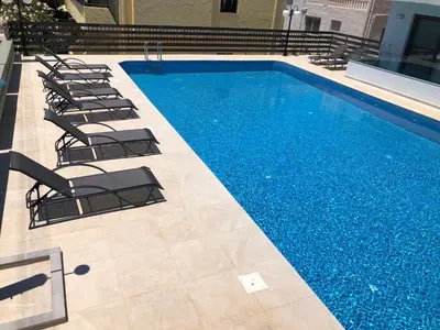 a swimming pool with lounge chairs next to it at Casa del Sol - Kalathas in Kalathas