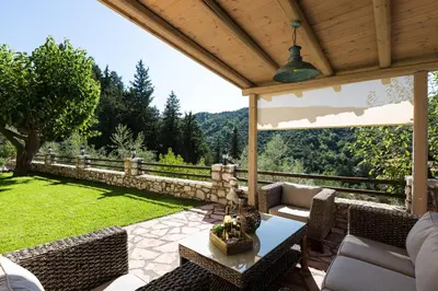 a patio with a table and chairs and a fence at Vrisali Traditional Stone Villa in Gerolakkos
