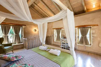 a bedroom with a large bed with a canopy at Vrisali Traditional Stone Villa in Gerolakkos