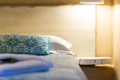 a bed with a blue and white pillow on it at Vrisali Traditional Stone Villa in Gerolakkos