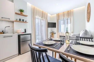 a kitchen and dining room with a table and chairs at Seatherial Apartments Paleochora in Palaiochóra