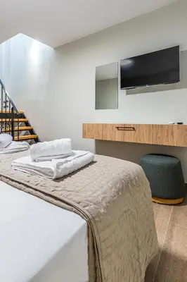a bedroom with a bed with a tv on the wall at Seatherial Apartments Paleochora in Palaiochóra