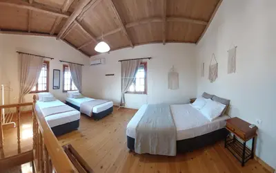 a bedroom with two beds in a room with wooden floors at Casa Cretese Chania in Tsikalariá