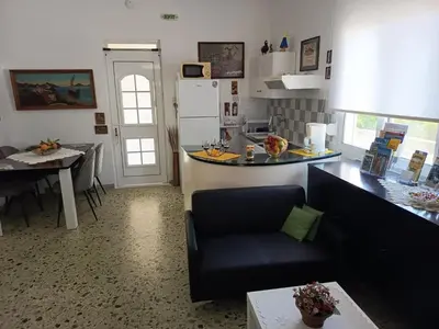 a kitchen and living room with a couch and a table at Veranda with endless view in Fournés