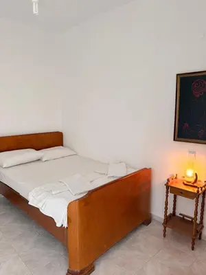 a bedroom with a bed and a night stand with a lamp at Retro Groove in Palaiochóra