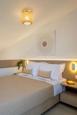 a bedroom with a large bed with white sheets and pillows at Aladdin Luxury Suites With Shared Pool in Galatás