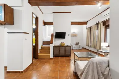 a living room with white walls and wooden floors at Spitatsi - Home with Yard in Chania Town