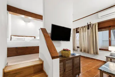 a room with a bed and a tv on a wall at Spitatsi - Home with Yard in Chania Town