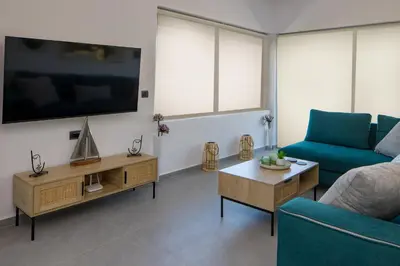 a living room with a blue couch and a tv at Lum Urban Suites in Chania Town