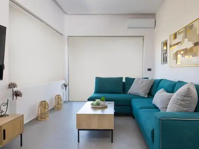 a living room with a blue couch and a coffee table at Lum Urban Suites in Chania Town