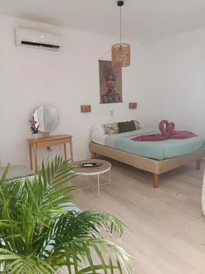 a bedroom with a bed and a table and plants at Menta Apartment's in Maleme