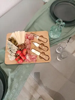a cutting board with cheese and fruit on a table at Menta Apartment's in Maleme