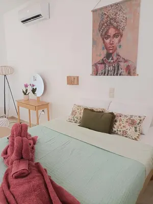 a bedroom with a bed with a painting on the wall at Menta Apartment's in Maleme