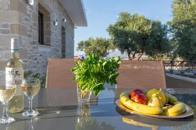 a plate of fruit on a table with a bottle of wine at ''Filoxenia'' of the 11 Brothers in Kissamos