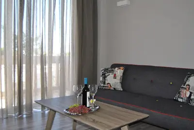 a living room with a table with a bottle of wine at Pantheon Aparthotel in Chania Town