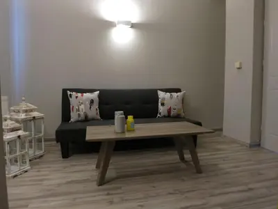 a living room with a black couch and a wooden table at Pantheon Aparthotel in Chania Town