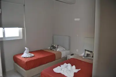 a room with two beds with towels on them at Pantheon Aparthotel in Chania Town