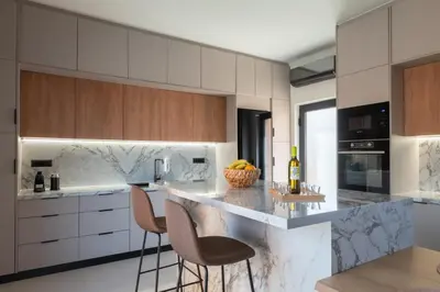 a kitchen with a counter with chairs and a bottle of wine at Madre Tierra Boutique Villa 3 in Potistíria