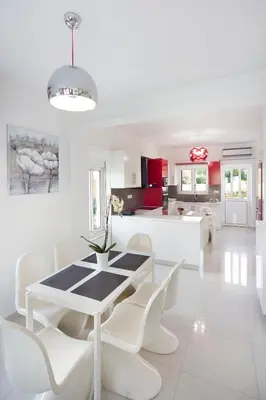 a white dining room and kitchen with a table and chairs at Andreas Villa in Kato Daratso
