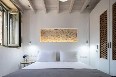 a bedroom with white walls and a bed with white pillows at Villa Manmar 2BR with Sleeping Lofts by etouri in Spiliá