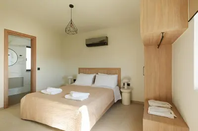 a bedroom with a bed with two towels on it at Madre Tierra Boutique Villa 4 in Potistíria