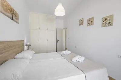 two beds in a room with white walls at Seafront Apartment in Chania 6 in Chania Town