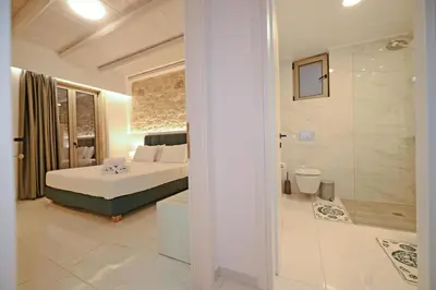 a bedroom with a bed and a bathroom with a shower at Koukis Villa With Sea View in Falasarna