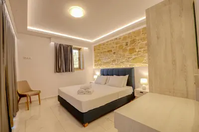 a bedroom with a bed and a chair in a room at Koukis Villa With Sea View in Falasarna